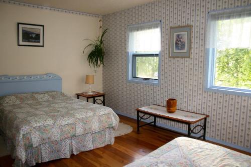 - une chambre avec 2 lits, une table et 2 fenêtres dans l'établissement Dunphy's Bed and Breakfast, à Parson