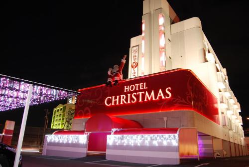 two people sitting on top of a hotel christmas sign at Hotel Christmas (Leisure Hotel) in Inazawa