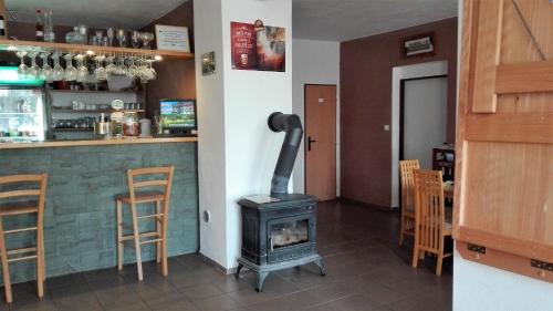 a bar with a wood stove in a restaurant at Hotel Sobol in Vranovska plaz