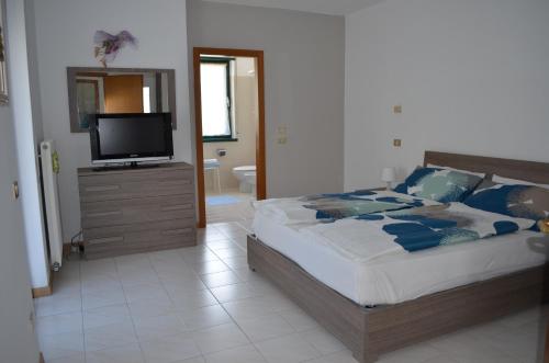Schlafzimmer mit einem Bett und einem Flachbild-TV in der Unterkunft BRIONE47 in Riva del Garda