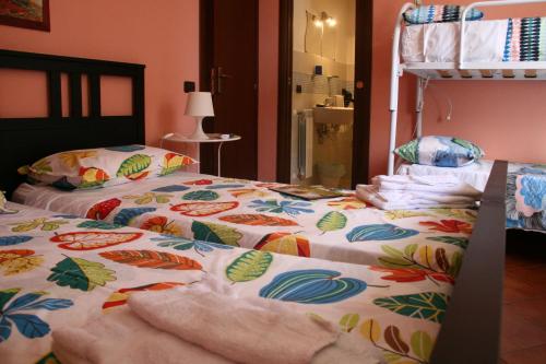 a bed with a colorful comforter on top of it at B&B Etna Country in Tremestieri Etneo