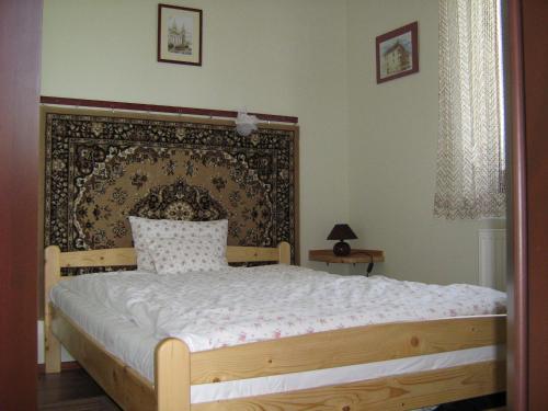 a bedroom with a bed with a black and white bedspread at Patakparti Apartman in Bozsok