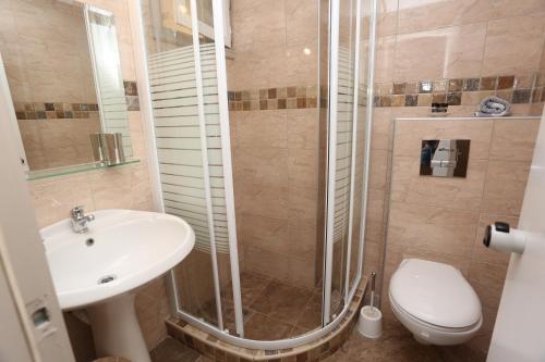 a bathroom with a shower and a toilet and a sink at Sun Hotel in Polykhrono