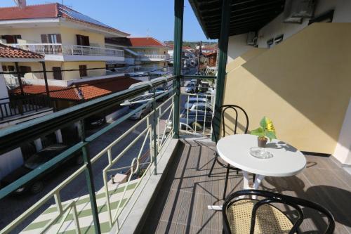a balcony with a table and chairs and a view at Sun Hotel in Polykhrono