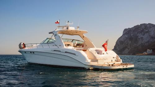 a white boat in the water with a mountain in the background at Luxury Yacht Hotel in Gibraltar