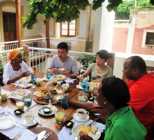a group of people sitting around a table eating at Jardim dos Aloés, Unique B&B - Casa de Charme in Ilha de Moçambique