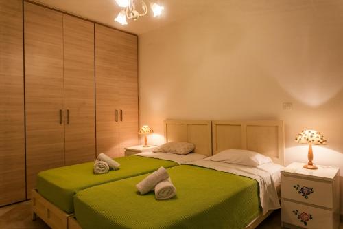a bedroom with two beds with green sheets at Porto Heli Villa in Porto Heli