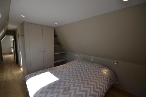 Un pequeño dormitorio con una cama en la esquina en Vakantiewoning Wanderlust, en Alveringem