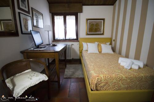 San Giorgio Di MantovaにあるA un passo da...のベッドルーム1室(ベッド1台、デスク、コンピュータ付)