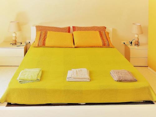 ディーゾにあるOikia Vacanze Diso Giuliaの黄色いベッド(タオル2枚付)