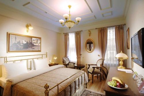 a bedroom with a bed and a chandelier at Darussaade Hotel Old City - Sultanahmet in Istanbul