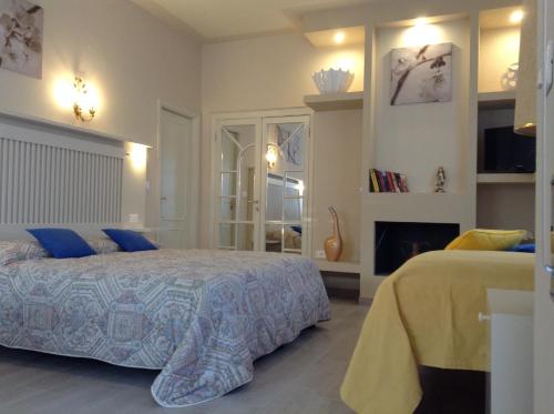 a bedroom with a bed with blue pillows and a fireplace at B&B Ortensia in Forte dei Marmi