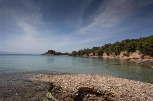 a large body of water with a rocky shore at Porto Heli Villa in Porto Heli