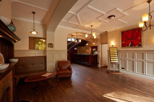 a living room with a chair and a table at Lismoyne Hotel in Fleet