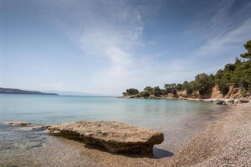 a rock sitting on the shore of a beach at Porto Heli Villa in Porto Heli