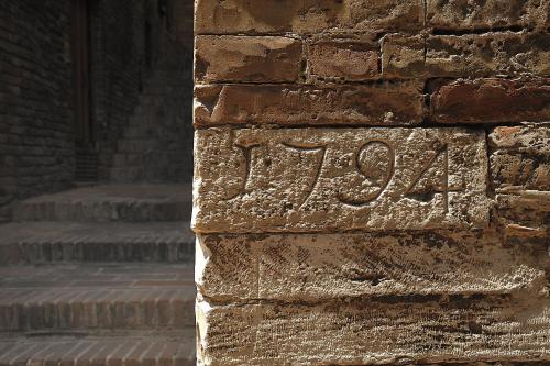 a stone inscription on the side of a brick wall at Albergo Hotel Raffaello in Urbino