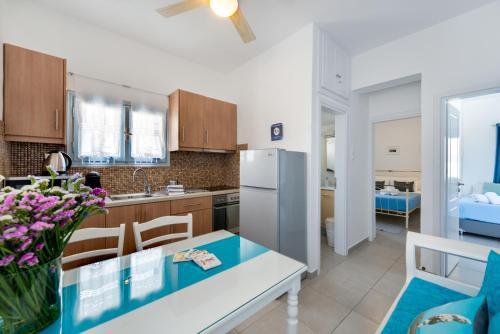 uma cozinha com uma mesa e um frigorífico em Folia Apartments em Fira