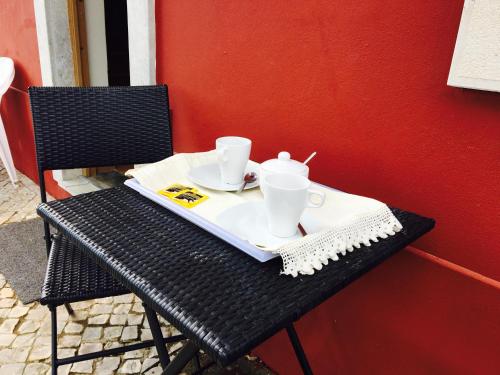 a black table with two cups and plates on it at Villa Monte da Alfarrobeira in Estói