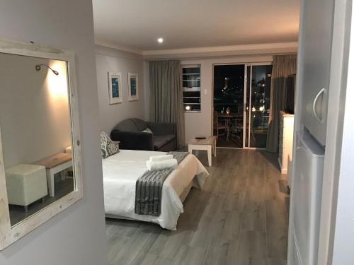 a bedroom with a bed and a living room at Ships Bell at Port St Francis in St Francis Bay