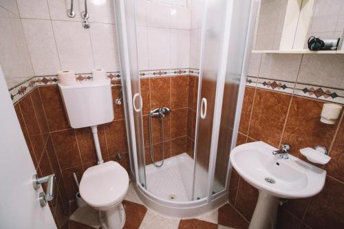 a bathroom with a shower and a toilet and a sink at Apartments Hollaj in Ulcinj