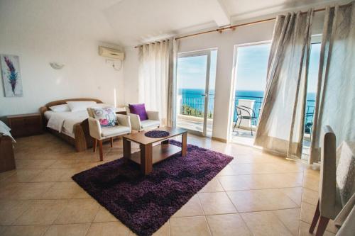 a bedroom with a bed and a room with a view of the ocean at Apartments Hollaj in Ulcinj
