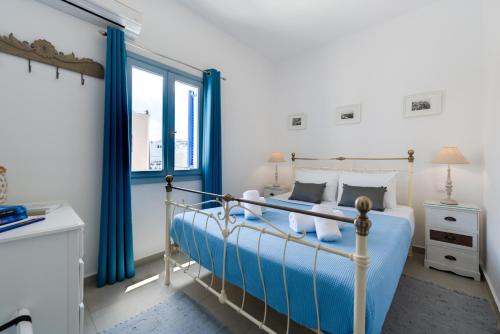 um quarto com uma cama e uma janela em Folia Apartments em Fira