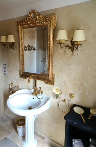 une salle de bain avec un lavabo et un miroir au mur dans l'établissement La Dame Au Balcon, à Roussillon