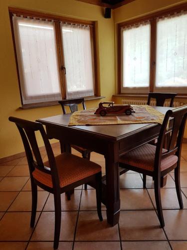 a dining room table with chairs and windows at Casa chanoux in Chambave