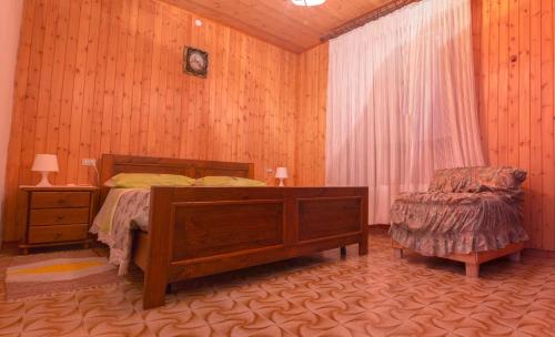 1 dormitorio con 1 cama y 1 silla en Pergolato alpino p.terra, en Teglio