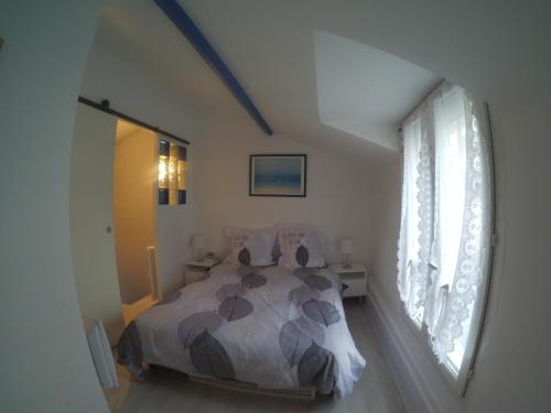 - une chambre avec un lit et une grande fenêtre dans l'établissement Maison de Pêcheurs en centre ville, à Deauville