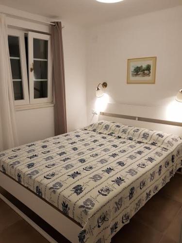 a bedroom with a bed with a blue and white comforter at Sea-esta 2 in Valun