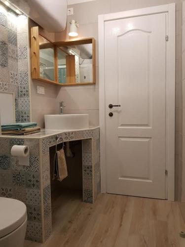 a bathroom with a toilet and a sink and a door at Sea-esta 2 in Valun