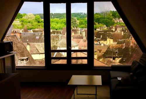 a view of a city from a large window at FRANRÉAL, 4 Appartements in Sarlat-la-Canéda