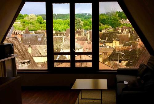 a view of a city from a large window at FRANRÉAL, 4 Appartements Climatisés in Sarlat-la-Canéda