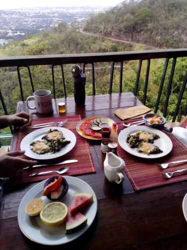 a table with plates of food on top of a balcony at Tranquility Estate in Kingston