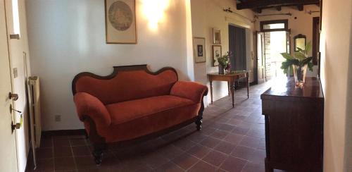 a living room with a red couch in a room at Casa Cecilia Country House in Salgareda
