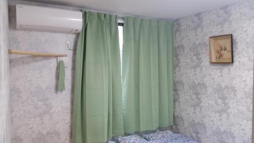 a room with a green curtain and a window at Tokyo Guest House 2020 in Tokyo