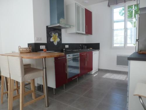 a kitchen with red cabinets and a wooden table at Château de Morin in Puch-dʼAgenais