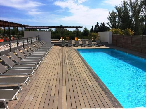 una piscina con sedie a sdraio e sedie su un patio di Les Terrasses D'Aix - Studio avec Grande Terrasse privée ad Aix en Provence