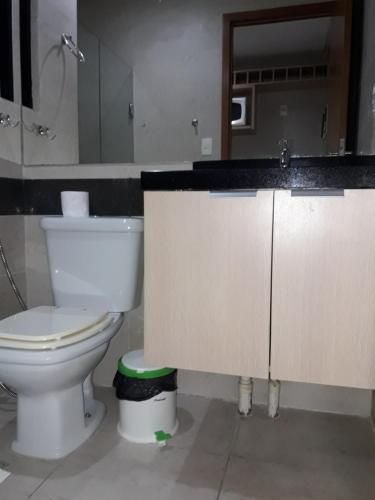 a bathroom with a toilet and a sink and a mirror at Mar do Cabo Branco Residence in João Pessoa