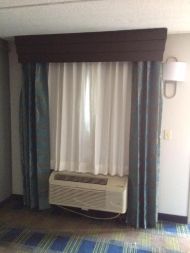a room with a window with a heater and a curtain at Lotus Inn and Suites Nashville in Nashville