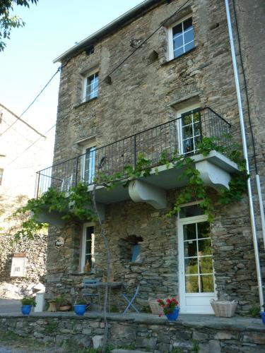Casa de piedra antigua con balcón en el lateral en Casa Valentini, en Quercitello