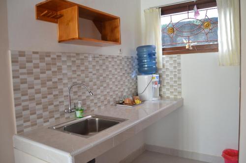 a kitchen counter with a sink and a window at Sakha House in Ubud