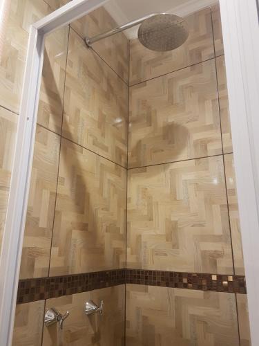 a shower with a glass door in a bathroom at Casa 24 Puerto Iguazu in Puerto Iguazú