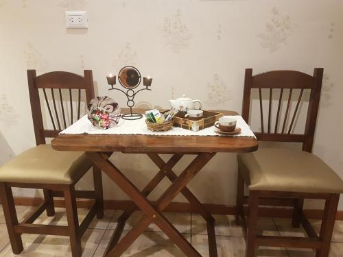 a dining room table with two chairs and a mirror at Casa 24 Puerto Iguazu in Puerto Iguazú