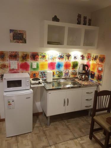 a kitchen with a sink and a microwave at Casa 24 Puerto Iguazu in Puerto Iguazú