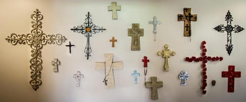 a bunch of crosses hanging on a wall at The Nunnery in Te Aroha