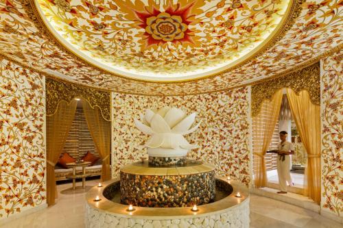a room with a ceiling with a statue in it at The Seminyak Beach Resort & Spa in Seminyak