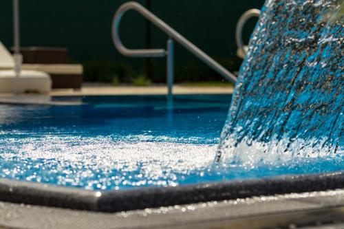 a pool with blue water coming out of it at Weinlodge Siedler in Mautern