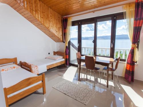 a room with two beds and a table and chairs at Villa Raljević in Stanići